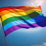 Bandera LGTBI ondeando ante un cielo despejado